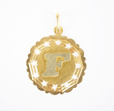 a close up of a gold pendant with the letter f on it