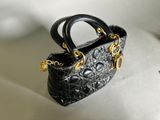 a small black purse that is sitting on a table