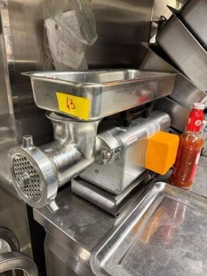 un hachoir à viande posé sur un plan de travail dans une cuisine
