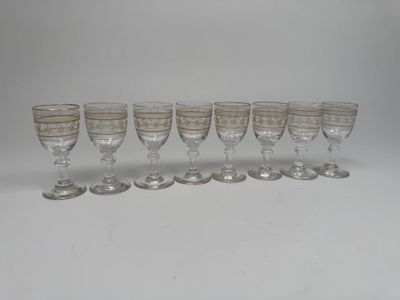 six wine glasses lined up in a row on a white surface