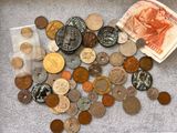 un tas de pièces de monnaie par terre, à côté d'un sac d'argent