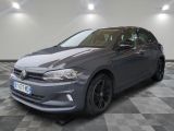 Une Volkswagen Golf grise est garée dans une pièce au sol carrelé.