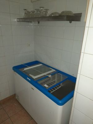 une petite cuisine équipée d'un évier et d'un lave-linge