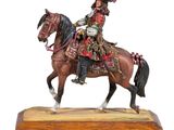 figurine of a man riding a horse on a wooden base