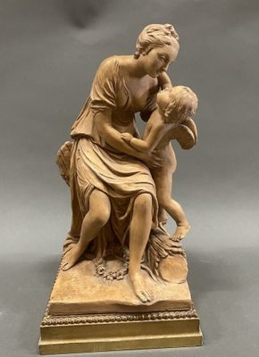 an antique statue of a woman holding a child on a marble base