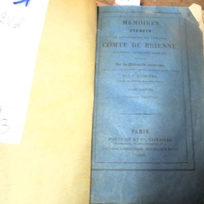 a blue book sitting on a table next to a cup of coffee