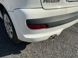 une voiture blanche garée dans un parking à côté d'un bâtiment