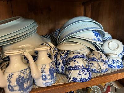 many blue and white plates and vases on a shelf
