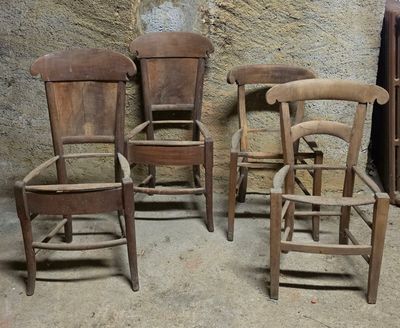 trois chaises en bois placées les unes à côté des autres devant un mur en pierre