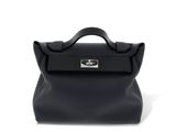 le petit sac noir est posé sur une surface blanche