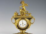 l'image d'une horloge en or posée sur une table
