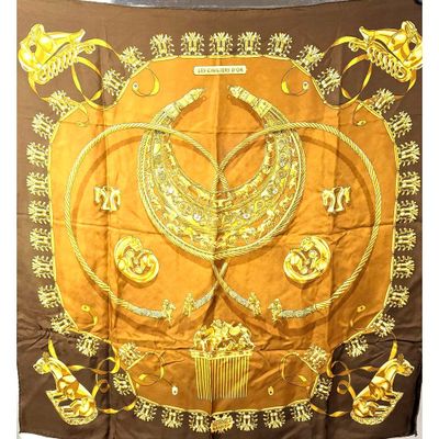 un gros plan sur une écharpe marron et jaune ornée de motifs dorés