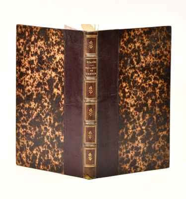 an old book with a brown cover sitting on top of a white table