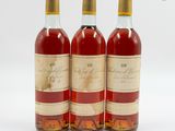 trois bouteilles de vin posées les unes à côté des autres sur une surface blanche