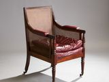 une image représentant une chaise avec une assise en cuir rouge et des pieds en bois