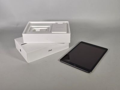 une tablette posée dans une boîte à côté d'un téléphone portable