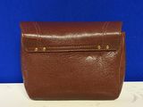 a brown leather purse on a white table