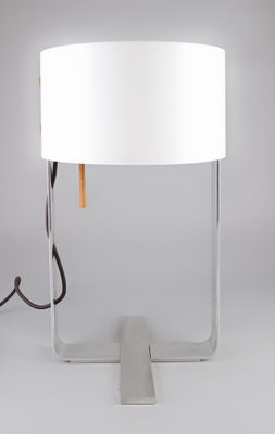 une lampe blanche posée sur une table, à côté d'une autre lampe blanche