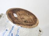 a white vase with a blue design on it