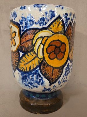 un vase bleu et blanc orné d'une fleur jaune