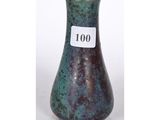 un vase vert sur lequel est accrochée une étiquette indiquant « 100 »
