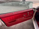 a red car with a glass top parked on the side of the road