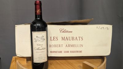 a bottle of wine sitting on top of a wooden barrel