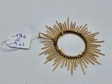 a close up of a gold sunburst on a white surface