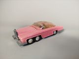 a pink toy car that is sitting on a white surface