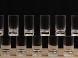 six shot glasses are lined up on a table with a black background