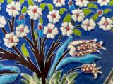 a close up of a decorative tile with flowers and birds on it