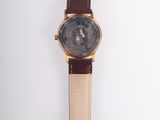 an image of a watch on a white surface with a brown strap