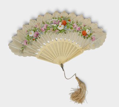 a white fan with flowers on it hanging from a string