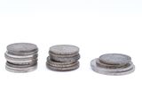 three stacks of coins sitting on top of each other on a white surface