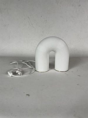 une lampe blanche posée sur une table blanche