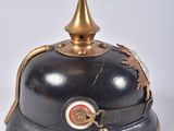 an old black helmet with a gold crown on top of it