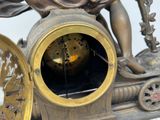 a bronze statue of a woman sitting on top of a clock