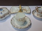 une table blanche recouverte d'une nappe blanche, sur laquelle sont posées des tasses et des soucoupes