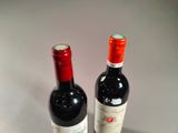 two bottles of wine sitting next to each other on a table