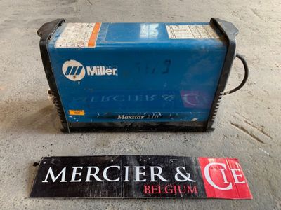 a blue machine sitting on the ground next to a sign