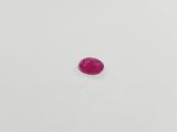 a single ruby stone on a white surface