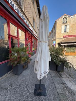 un parapluie blanc fixé à un mât devant un immeuble