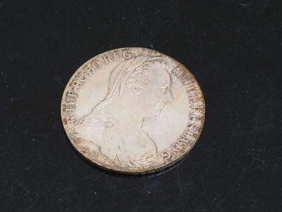 une vieille pièce de monnaie représentant la tête d'une femme sur un fond noir