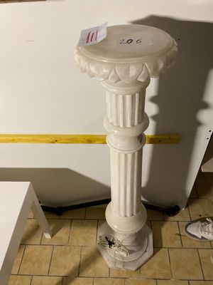 un socle blanc au milieu d'un sol carrelé