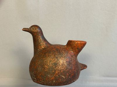 a brown bird shaped vase sitting on a table
