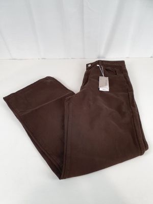 un pantalon marron posé sur une surface blanche
