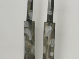 deux vases noirs et blancs posés l'un à côté de l'autre sur une surface blanche