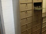 a tall cabinet with many drawers in it in a room