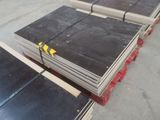 une pile de tôles d'acier posée sur des palettes dans un entrepôt