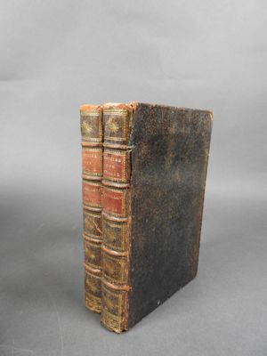 un vieux livre posé sur une table à côté d'un fond gris